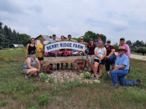 group of people in front of farm sign