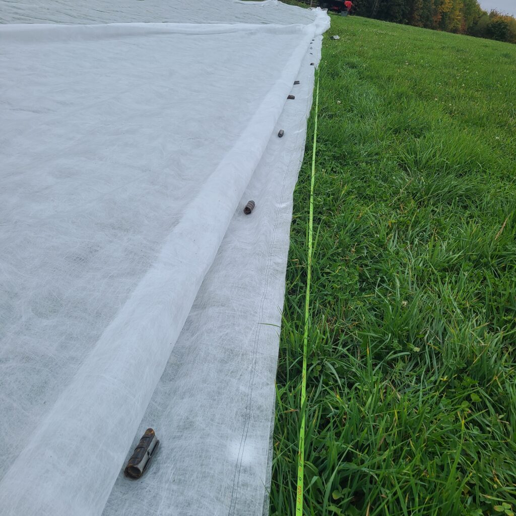 Photo of netting hardware laid out along Typar row cover.