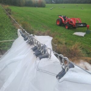 Photo showing the carabiners used to hang the row cover from the guy wire.