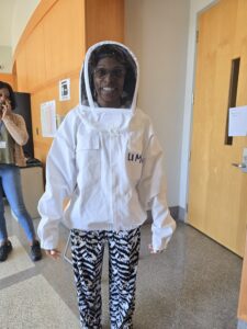 Vet farmer demonstrating protective suit for field chemical spraying