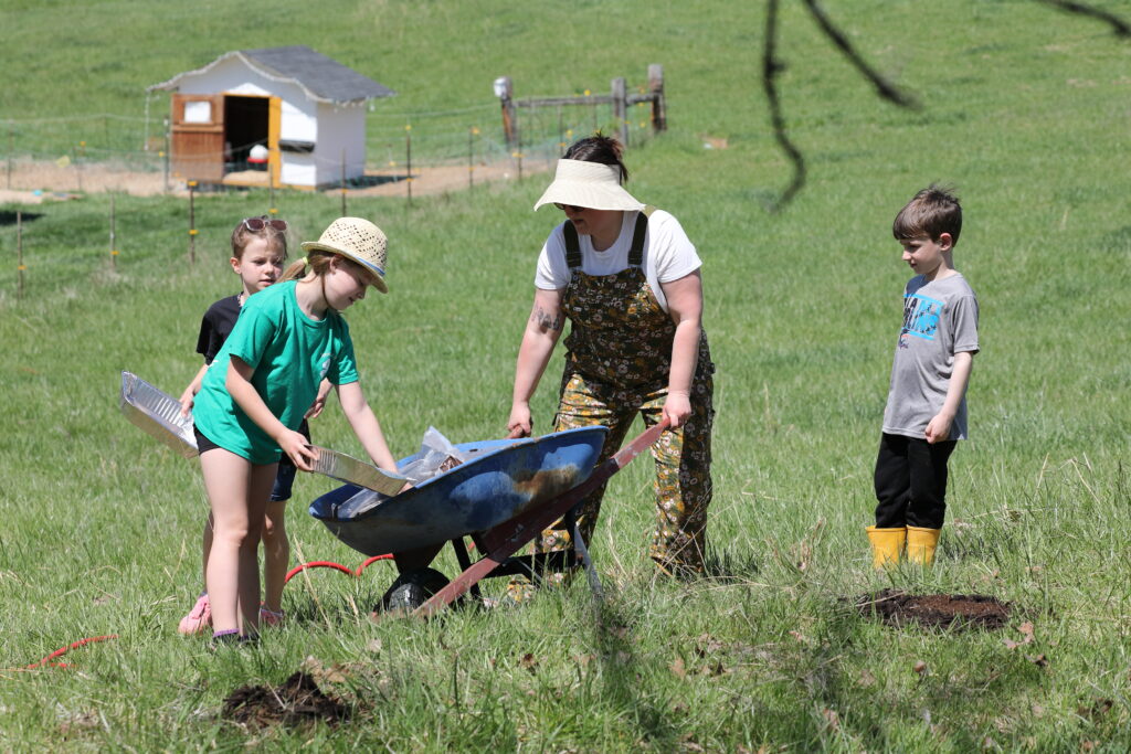 Participants scoop mulch from a wheel barrel