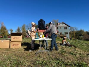 Two beekeepers practice installing an overwintering wrap on a hive for outdoor overwintering.