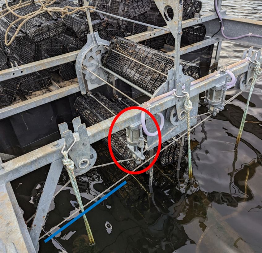 Old 2024 drive system design using a steel cable (underlined in blue) and hydraulic tensioners (circled in red). This drive system connects a row of solar rotators to the main driveshaft.