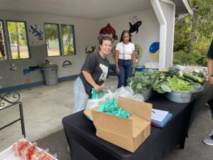 Patricia and Tiffany passing out farm fresh goodness at the produce stand