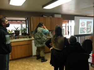 More workshop attendees crowd into the kitchen to learn.