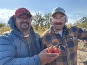 Rodrigo Cala and Javier Garcia holding Jalapeños they grew