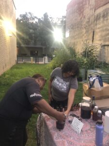 Spring 2025 Ecopreneur workshop with Tobias Fox and Roxana Marroquin at the Healing Garden. Marroquin begins a hands-on portion of the workshop when she leads participants through creating Elderberry Syrup.