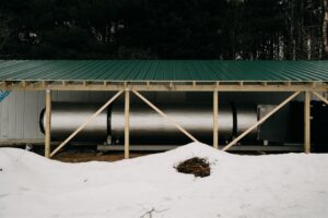 Actium composter on gravel pad with shed roof