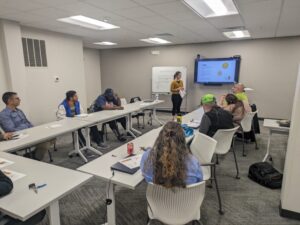 Students in a classroom view a presentation and lecture on Brand Identity.