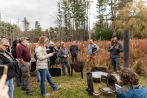 people in a field looking at biochar kilns