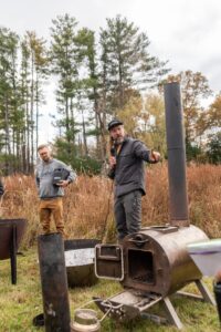 man standing next to a High plains biochar barrel stove