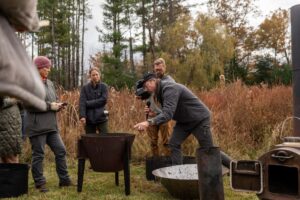 person discussing various biochar kilns outside 