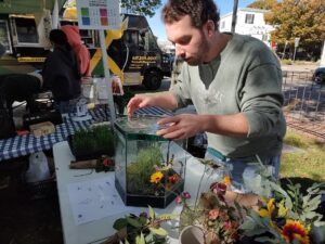 Man in front of terrarium at with plants on the table