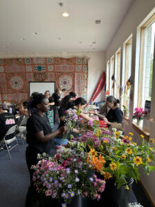 Employees selling cut flowers to customers at an indoor market