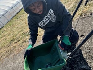 Te'Lario casting pollinator seeds for his pollinator patch