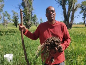 A farmer holds a shovelful of soil in a pasture in Kansas.