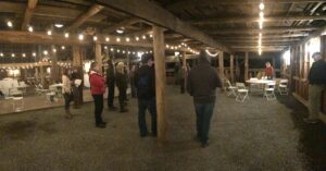 People standing and talking in a barn