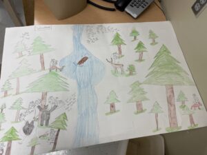 A drawing of woodlands showing trees, animals, and a rier.