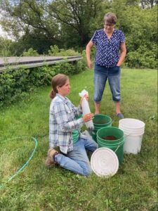 Stephanie demonstrating a compost extraction using the five-gallon bucket method scaled most appropriately for home gardeners