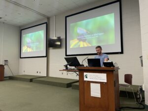 Person at podium with screen in back