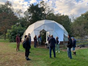 Farmers on a tour at OASIS in New Jersey.  Standing in Front of a greenhouse dome