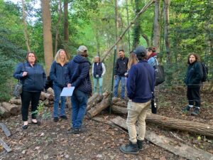 Farmers on a tour at OASIS in New Jersey.  Farmers are observing mushroom production in the woods.