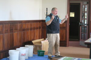 Mark King presenting with compost material buckets behind