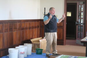 Mark King presenting with compost material buckets behind