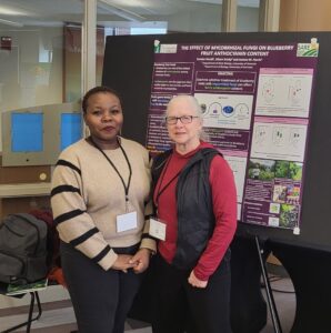 Sandra presenting her poster to a participant at the NOFA conference 2024