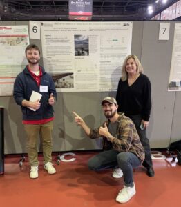 Student and two project partners with poster