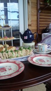 Photo of Tea at the Vintage Homesteader showing fancy sandwiches and place settings.