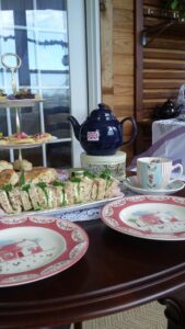 Photo of Tea at the Vintage Homesteader showing fancy sandwiches and place settings.