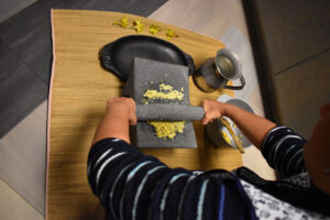 Teaching how to grind maize with a Metate.  Photo by Gerardo Morales