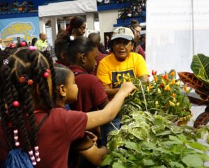 Children inspect the sensory vegetable and herb garden on display at the National Agriculture Day event.